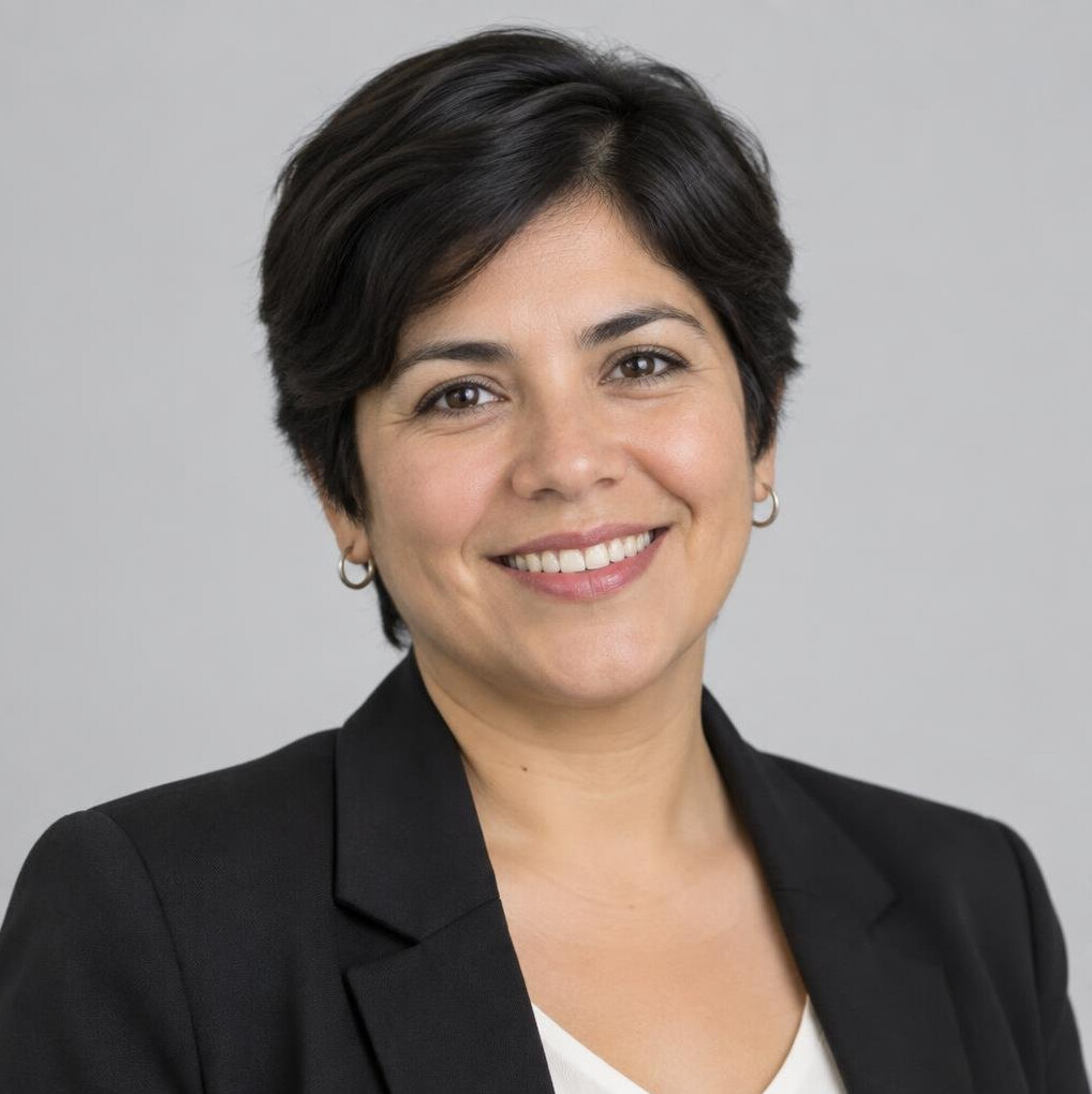 Studio portrait of a Chilean woman in her 40s with short dark hair smiling warmly